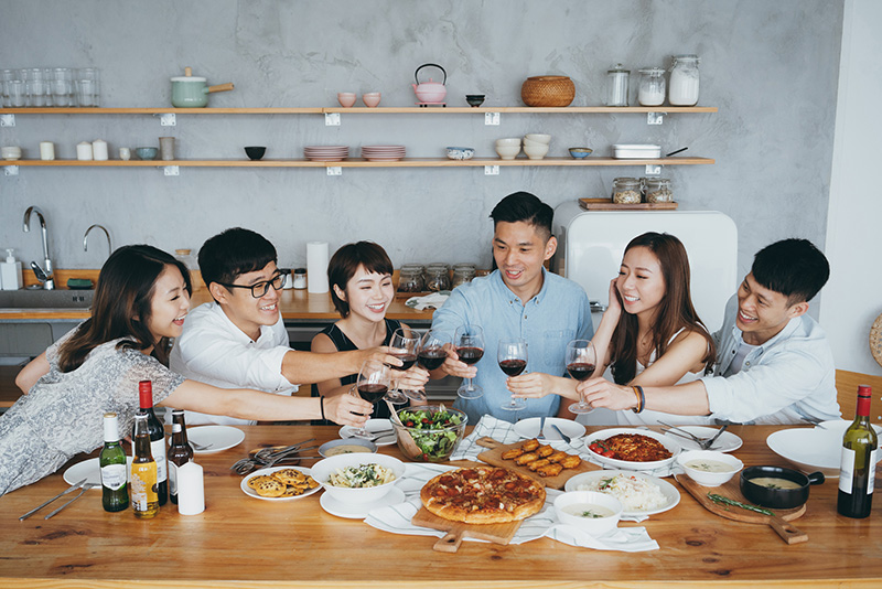 Group of happy young Asian man and woman having fun toasting and celebrating with red wine during party